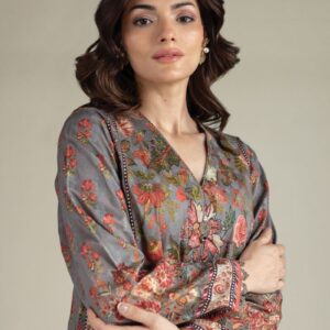A model wearing a A112-26-101EE2 2-piece lawn suit by Khaadi. The outfit features a long kurta with intricate vertical patterns and detailed borders, paired with dyed trousers and a matching printed dupatta with striped and floral designs. The model stands against a plain background, holding the dupatta, with product fabric details displayed on the left side.
