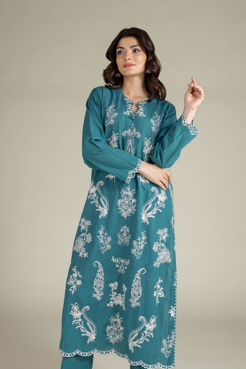A model wearing a A113-26-109EG2 2-piece lawn suit by Khaadi. The outfit features a long kurta with intricate vertical patterns and detailed borders, paired with dyed trousers and a matching printed dupatta with striped and floral designs. The model stands against a plain background, holding the dupatta, with product fabric details displayed on the left side.
