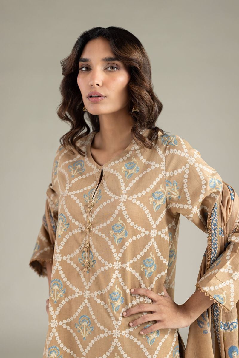A model wearing a A22-26-111FI2 3-piece lawn suit by Khaadi. The outfit features a long kurta with intricate vertical patterns and detailed borders, paired with dyed trousers and a matching printed dupatta with striped and floral designs. The model stands against a plain background, holding the dupatta, with product fabric details displayed on the left side.