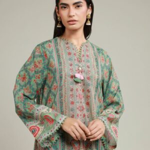 A model wearing a T-A112-26-102EB2 2-piece lawn suit by Khaadi. The outfit features a long kurta with intricate vertical patterns and detailed borders, paired with dyed trousers and a matching printed dupatta with striped and floral designs. The model stands against a plain background, holding the dupatta, with product fabric details displayed on the left side.